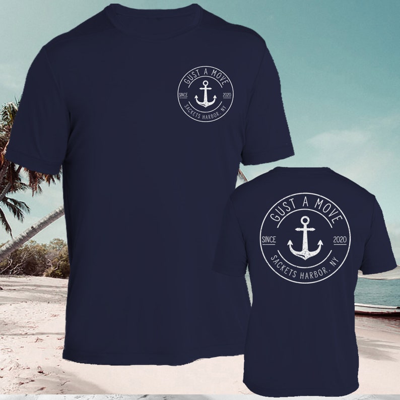 May include: A navy blue t-shirt with a white anchor logo on the front and back. The logo says "GUST A MOVE" with "SINCE 2020 SACKETS HARBOR, NY" around the anchor.