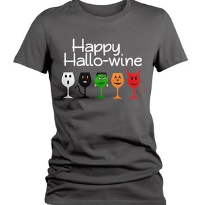 K&ouml;nnte beinhalten: Ein dunkelgraues T-Shirt mit dem Text "Happy Hallo-wine" und einer Reihe von f&uuml;nf Weingl&auml;sern mit Halloween-Motiven. Die Gl&auml;ser sind wei&szlig;, schwarz, gr&uuml;n, orange und rot.