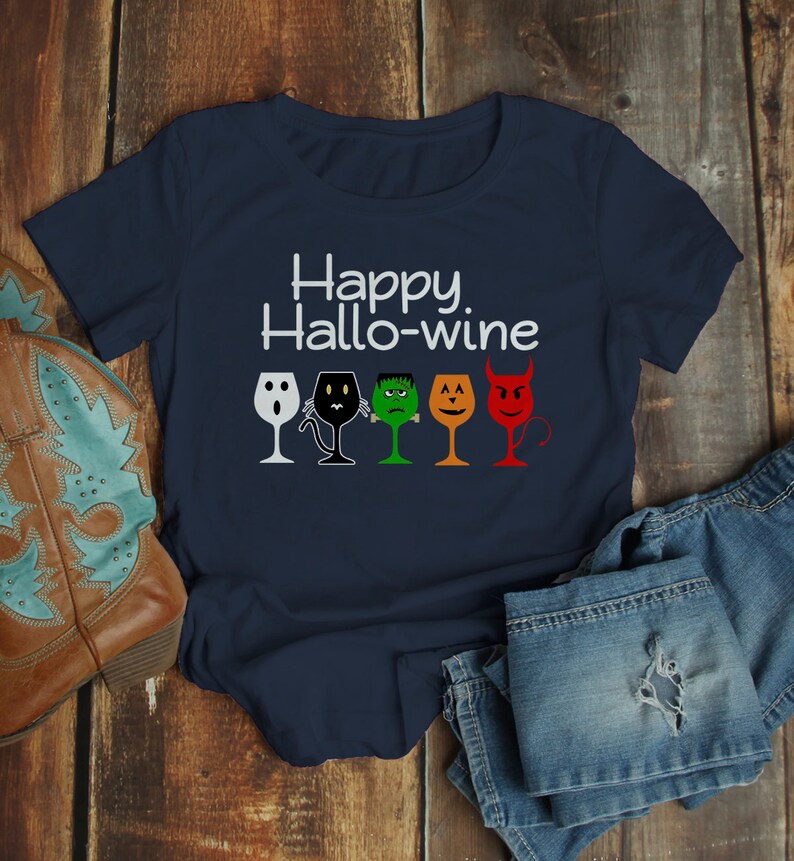 K&ouml;nnte beinhalten: Ein marineblaues T-Shirt mit dem Text "Happy Hallo-wine" und einer Reihe von f&uuml;nf Weingl&auml;sern mit verschiedenen Halloween-Charaktergesichtern.