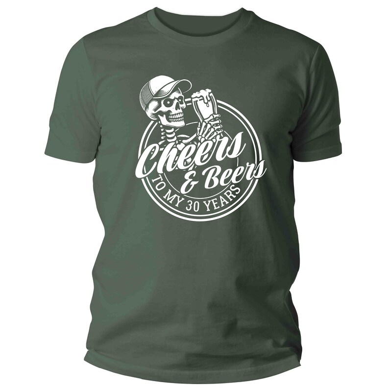 May include: A dark green t-shirt with a white graphic of a skeleton wearing a cap and holding a beer mug. The graphic is inside a circle with the words "Cheers & Beers To My 30 Years".