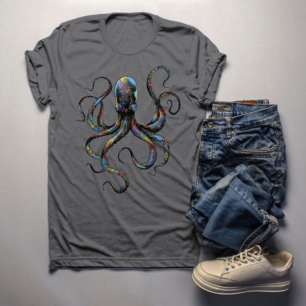 May include: A gray t-shirt with a colorful octopus graphic print. The octopus has eight tentacles and is surrounded by a black outline. The shirt is paired with blue jeans and white sneakers.