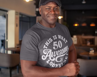 May include: A gray t-shirt with a white graphic that says "This is what 50 and awesome looks like".