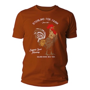 Peut inclure: Un t-shirt marron avec une illustration de coq et le texte "Sterling Fox Farm - Since 2017 - Support Local Farming - Salmon River, New York"