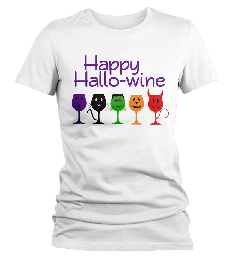 K&ouml;nnte beinhalten: Wei&szlig;es T-Shirt mit dem Text "Happy Hallo-wine" in lila Schrift. F&uuml;nf Weingl&auml;ser mit verschiedenen Halloween-Charaktergesichtern sind unter dem Text aufgereiht.