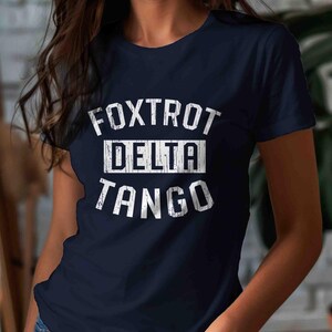 May include: A navy blue t-shirt with white text that reads "FOXTROT DELTA TANGO".