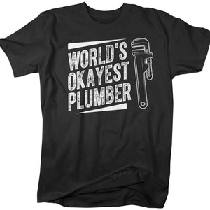 May include: Black t-shirt with white text that reads "World's Okayest Plumber" and a white wrench graphic.