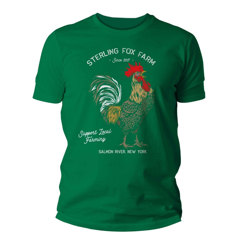 Peut inclure: T-shirt vert avec une illustration de coq blanc et le texte "Sterling Fox Farm - Since 2017 - Support Local Farming - Salmon River, New York"
