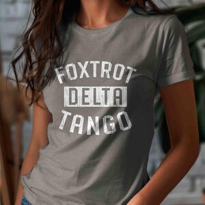 May include: Gray t-shirt with white text that reads "FOXTROT DELTA TANGO".