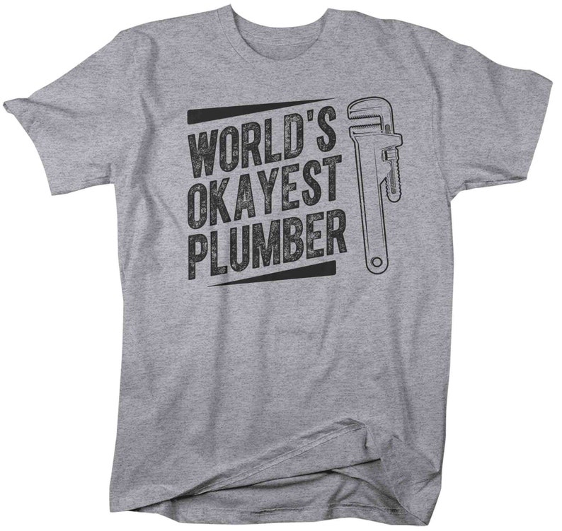 May include: Gray t-shirt with black text that reads "World's Okayest Plumber" and a black and white illustration of a wrench.
