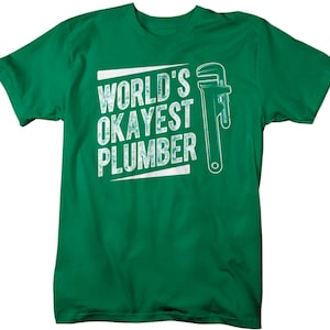 May include: Green t-shirt with a white graphic that says "World's Okayest Plumber" and a wrench illustration.