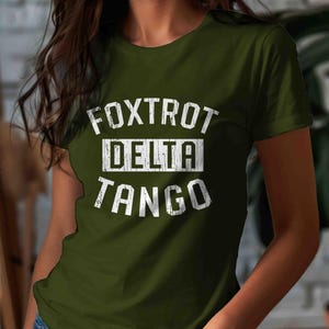 May include: A green t-shirt with a white graphic print that says "FOXTROT DELTA TANGO".