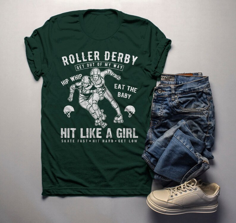May include: Green t-shirt with a white graphic of two roller derby players. The text on the shirt reads "Roller Derby Get Out Of My Way Hip Whip Eat The Baby Hit Like A Girl Skate Fast Hit Hard Get Low".