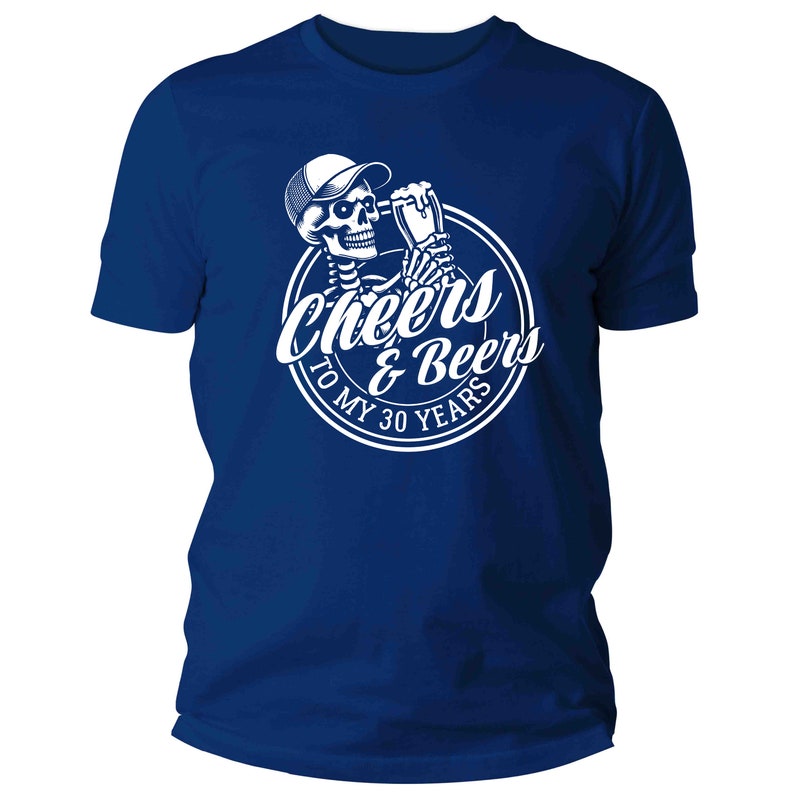May include: A royal blue t-shirt with a white graphic of a skeleton in a cap, toasting with a beer. The graphic is in a white circle with the text "Cheers & Beers To My 30 Years".