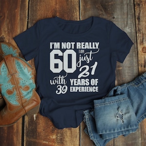 May include: A navy blue t-shirt with white text that reads "I'm not really 60 I am just 21 with 39 years of experience".