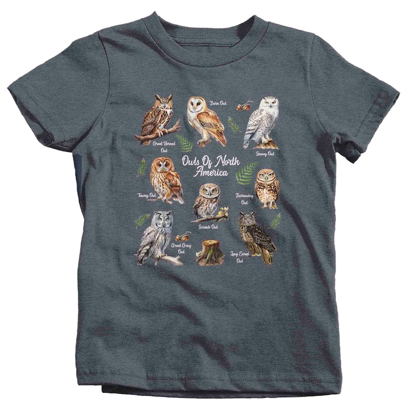May include: A dark blue t-shirt with a graphic of different types of owls from North America. The owls are illustrated in a watercolor style and are labeled with their names. The text "Owls Of North America" is printed in white on the shirt.