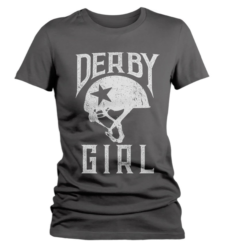 May include: A dark gray t-shirt with a white graphic of a roller derby helmet with a star and the text "DERBY GIRL".