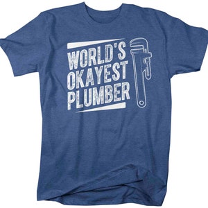 May include: A blue t-shirt with white text that reads "World's Okayest Plumber" and a white wrench graphic.