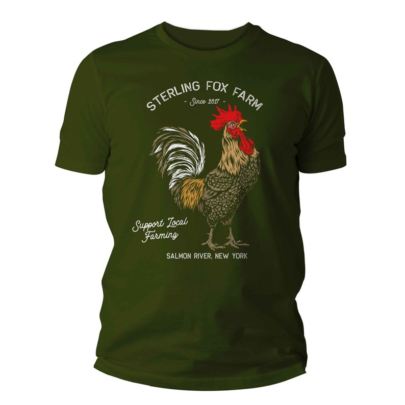Peut inclure: Un t-shirt vert avec un graphique blanc d'un coq et le texte "Sterling Fox Farm - Since 2017 - Support Local Farming - Salmon River, New York"