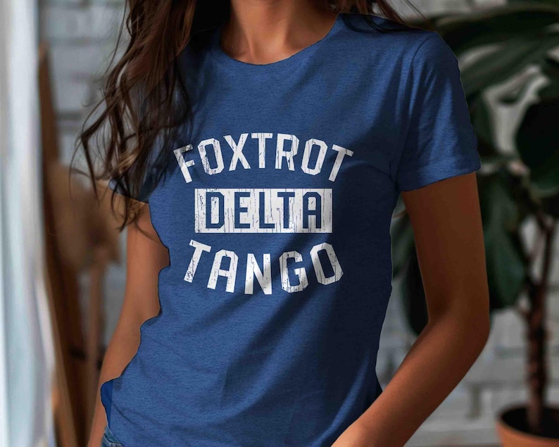 May include: A blue t-shirt with white text that reads "FOXTROT DELTA TANGO".