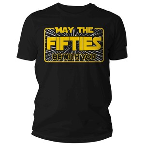 K&ouml;nnte beinhalten: Schwarzes T-Shirt mit einer gelben Grafik, auf der in einer von Star Wars inspirierten Schriftart "M&ouml;gen die F&uuml;nfziger mit dir sein" steht.