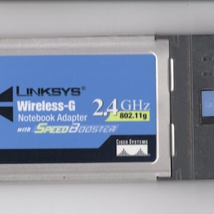 May include: A silver Linksys Wireless-G Notebook Adapter with SpeedBooster, featuring a blue label with the text "2.4 GHz 802.11g".