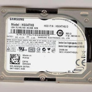 May include: A Samsung HS04THB 40.0GB hard disk drive with a metallic silver frame and a white label containing technical specifications, serial number S17NJ16S400323, model information, regulatory symbols, and manufacturing details from Korea.