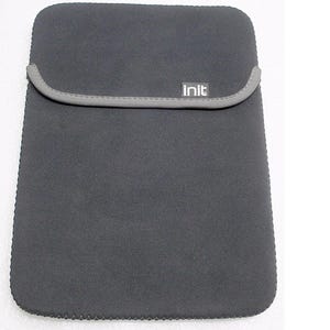 May include: A dark gray laptop sleeve with a gray trim and the word "init" printed on the front. The sleeve is made of a soft, flexible material and is designed to protect a laptop. The sleeve is rectangular and has a flap closure.