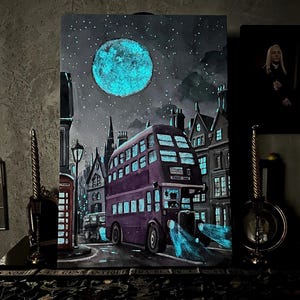 Può includere: Un dipinto di un autobus a due piani viola che guida attraverso una città di notte. L'autobus ha fari e finestre blu luminosi. La luna è piena e brilla di blu. Il cielo è scuro con le stelle.