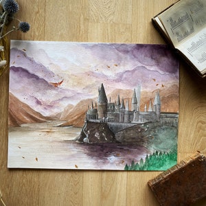 Op de afbeelding: Waterverf schilderij van Zweinstein, een fictieve school voor hekserij en tovenarij, tegen een achtergrond van paarse en oranje bergen en een meer. Het kasteel is afgebeeld in een realistische stijl met gedetailleerde architectuur en een dramatische lucht.