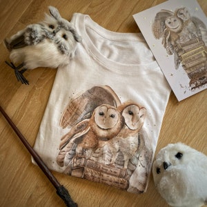 LIMITED EDITION Wizard Magic World T-Shirt Mädchen – Eulen über einem Stapel Zauberschulbücher mit Gold + A5-Postkarte