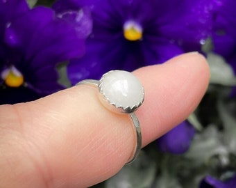 Handmade sterling silver ring with an 8mm white Jade cabochon in a serrated setting