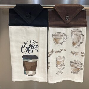 Könnte beinhalten: Zwei weiße Küchentücher mit braunen und schwarzen Stoffoberteilen. Ein Handtuch hat den Text "But First Coffee" und eine Zeichnung einer Kaffeetasse. Das andere Handtuch hat Zeichnungen von Kaffeetassen und Kaffeebohnen.