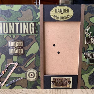 Könnte beinhalten: Ein brauner Holzrahmen mit Tarnmuster und jagdbezogenen Dekorationen. Der Rahmen hat einen Ausschnitt für ein Foto und enthält Text, der "Hunting", "Locked & Loaded", "Danger Men Hunting", "Big Buck", "Hunting Trip" und "Looking Good in Camo" lautet.