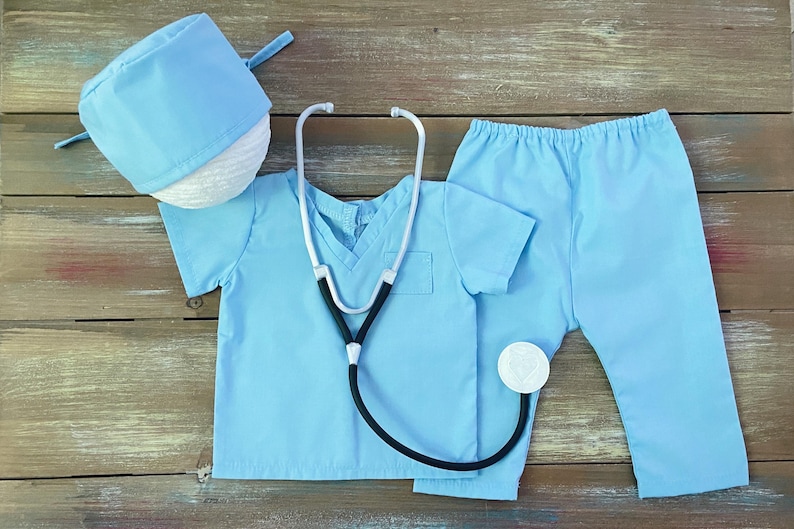 May include: A light blue doctor costume for kids, including a scrub top, pants, and a hat. The costume also includes a toy stethoscope.