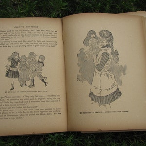 May include: An open book with black and white illustrations. The book is titled "Bonny's Fortunes" and features text from the story. The illustrations depict children in various scenes.