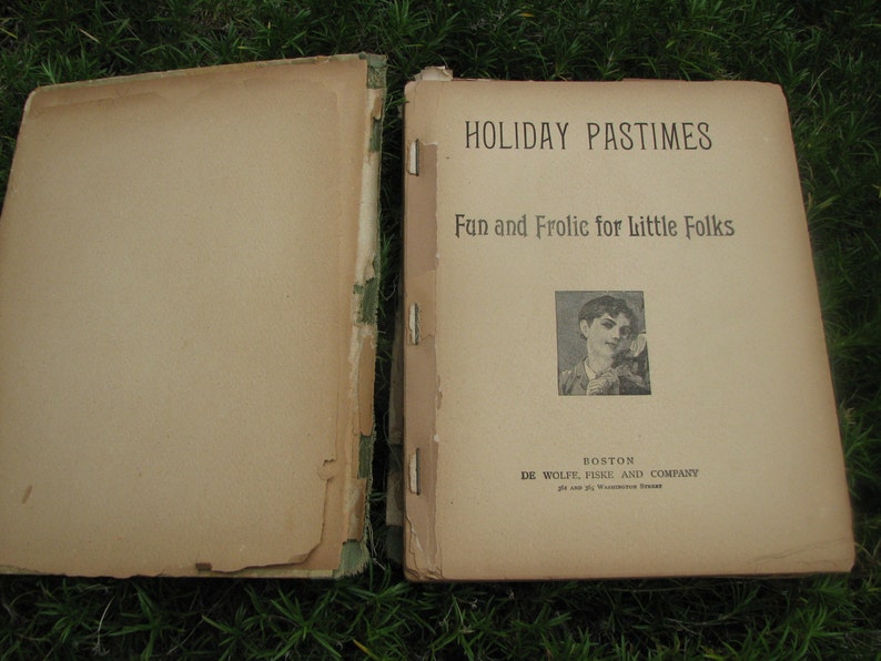 May include: A vintage book titled "Holiday Pastimes: Fun and Frolic for Little Folks" with a black and white illustration of a child on the cover. The book is published by De Wolfe, Fiske and Company in Boston.