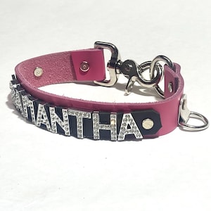 Può includere: Collare per cani in pelle rosa con una fibbia argentata e il nome "Samantha" scritto in lettere nere con strass.