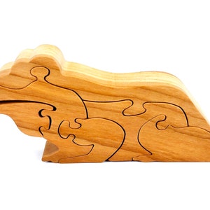 May include: A wooden puzzle in the shape of a frog. The puzzle is made of multiple interlocking pieces.