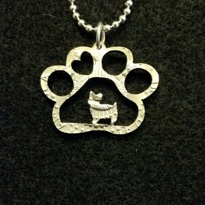 Yorkie in a pawprint coin jewelry pendant cut from a Kennedy half dollar coin