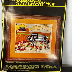 May include: A vintage Vogart Crafts Crewel Creative Stitchery Kit, featuring a framed "Farm Sunset" design. The kit includes stamped needlecraft homespun, acrylic crewel yarns, embroidery floss, and an embroidery needle. The frame size is 8 in. x 10 in.
