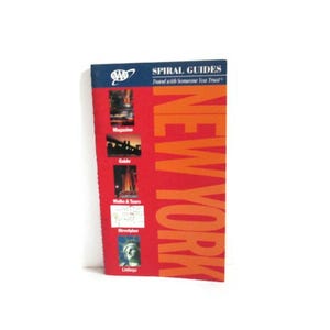 May include: A New York travel guide with a red and orange cover. The guide features the text "NEW YORK" in large orange letters. The cover also includes images and the words "Magazine", "Guide", "Walks & Tours", "Streetplan", and "Listings".