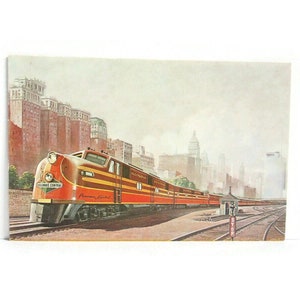 May include: Vintage postcard featuring a red and gold Illinois Central Railroad passenger train, the "Panama Limited," against a backdrop of city buildings. The train is on tracks with a stop sign.