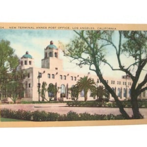 May include: Vintage postcard featuring the New Terminal Annex Post Office in Los Angeles, California. The building is a light beige color with a domed roof and arched windows. The postcard has a sepia tone and includes text at the top.