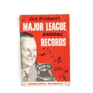May include: A vintage red paperback book titled Jack Brickhouse's Major League Baseball Records 1900-1952 Inclusive. The cover features a black and white portrait of a man, a WGN-TV microphone, and small black illustrations of baseball players.