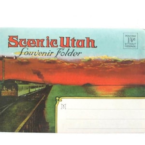 May include: A rectangular souvenir folder titled Scenic Utah with a vintage illustration of a train traveling along a track at sunset. The design features a red and orange sky, a green landscape, and a white area with lines for writing an address.