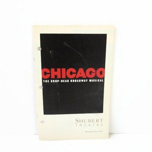 May include: A vintage Chicago The Drop-Dead Broadway Musical playbill from the Shubert Theatre, dated July 1997. The cover features a bold red Chicago logo centered on a black rectangular background, with three punched holes along the left side.