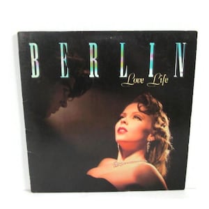 May include: A vintage vinyl record album cover for "Berlin" featuring the title "Love Life." The cover art depicts a man and woman in a romantic pose, with the woman looking up. The album title is in a stylized font.