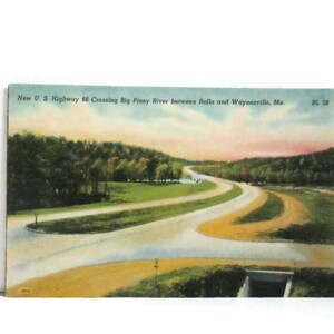 May include: A vintage postcard featuring a colorized landscape illustration of New U.S. Highway 66 crossing the Big Piney River between Rolla and Waynesville, Missouri. The scene depicts a winding road, green hills, and a sunset sky.