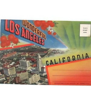 May include: Vintage postcard featuring a colorful aerial view of Los Angeles, California. The postcard has the words "Wonderful Los Angeles" in red and white, with illustrations of red fruit. The word "California" is also visible.