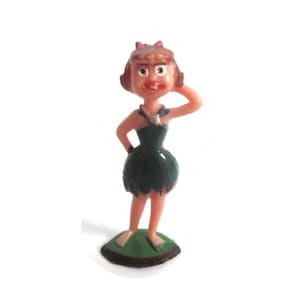 May include: A small plastic figurine of a cartoon character with reddish-brown hair, a peach-colored complexion, and a dark green dress with a jagged hemline. The character stands on a green base, one hand behind the head, with a wide, open-mouthed expression.